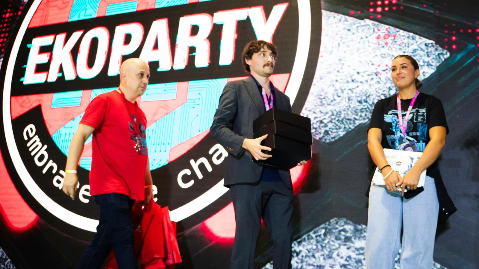 Organizadores y sponsors subiendo los premios al escenario frente a la pantalla de Ekoparty