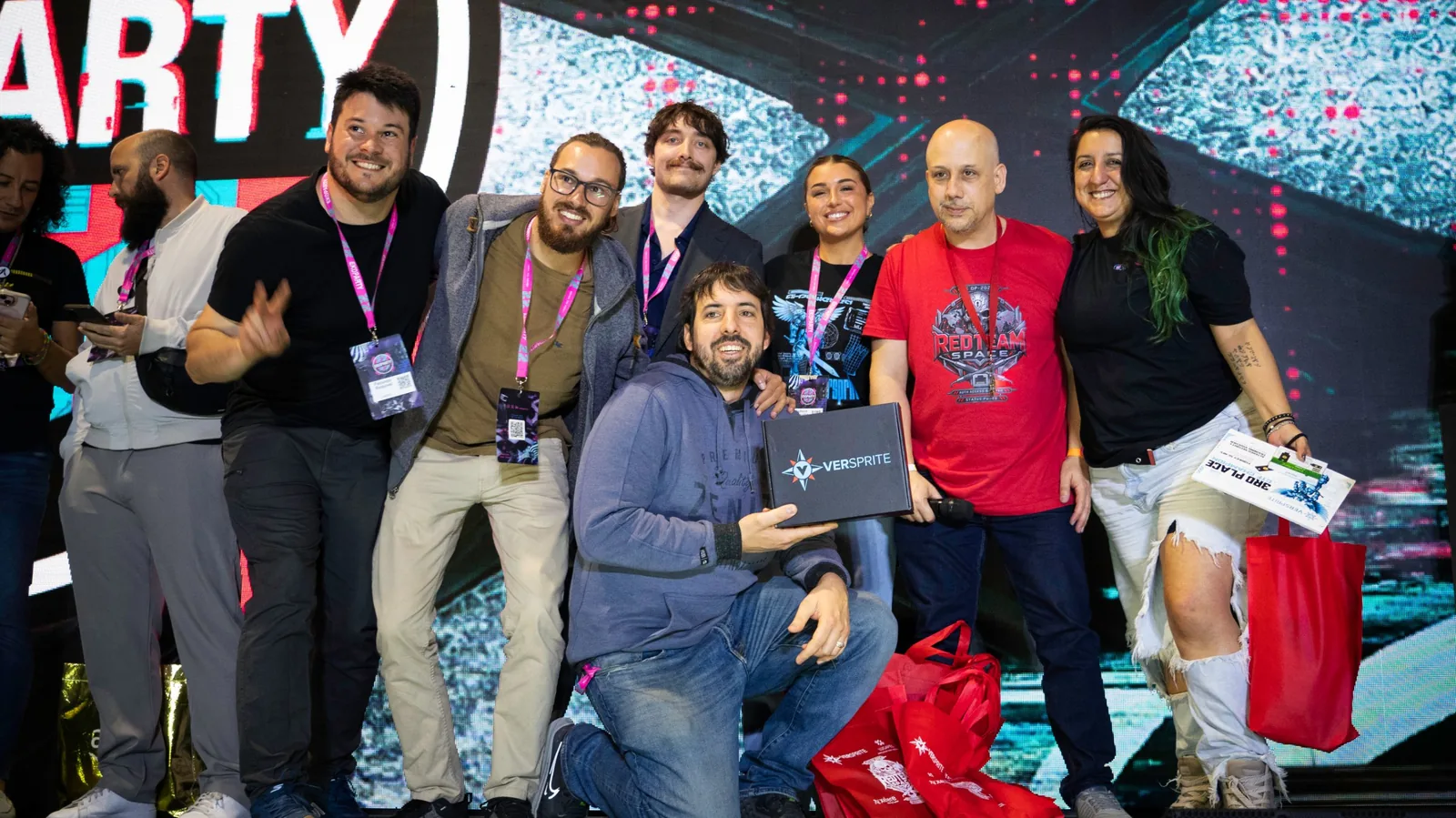 Equipo del tercer puesto del CTF celebrando en el escenario con sponsors y organizadores