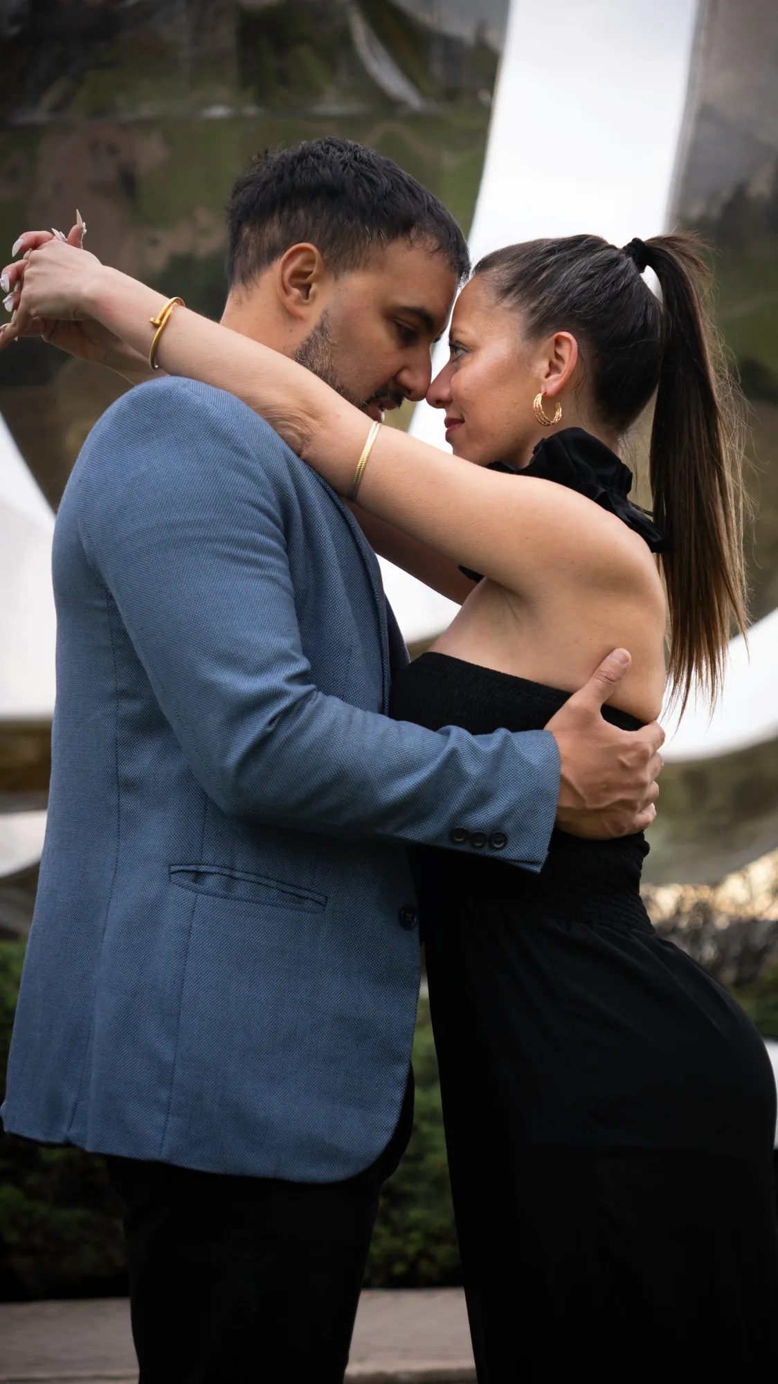 Abrazo de la pareja con los pétalos de la Floralis Genérica detrás