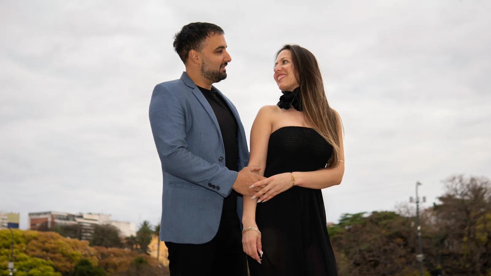 Retrato de la pareja mirándose con árboles y edificios de Recoleta de fondo